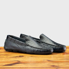 Pair of Blue leather loafer on a wooden surface with a light gray background