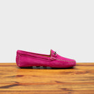 Pink loafers on a wooden surface with a white background