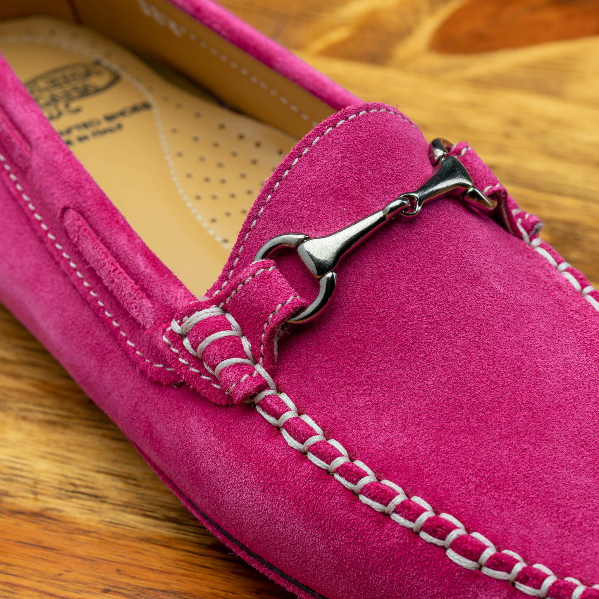 Close-up of pink loafers on a wooden surface