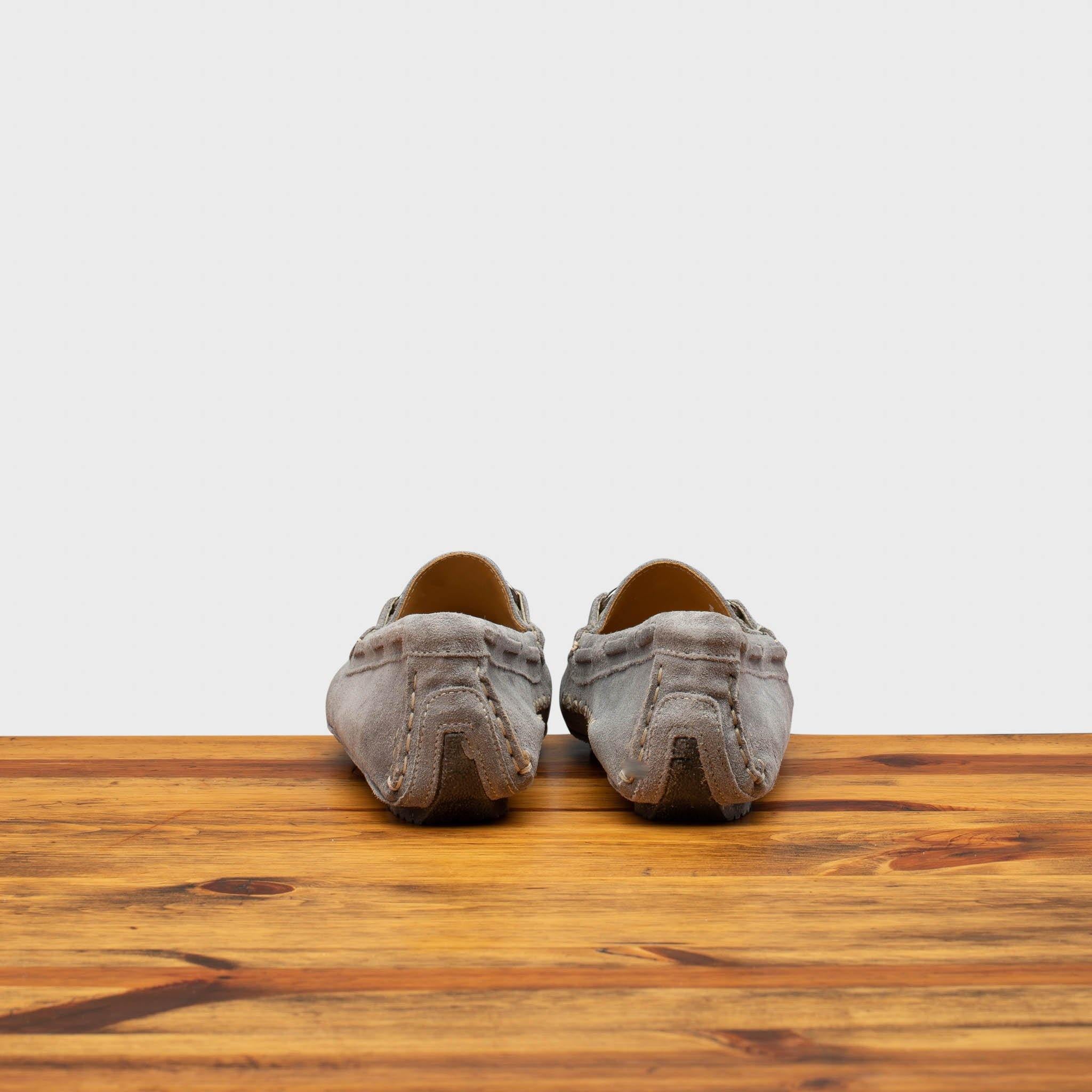 Back view of Silver velour suede driver shoes with a metallic bit, placed on a wooden surface.