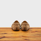 Back side of rope velour suede driver shoes with a metallic bit, placed on a wooden surface.