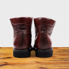 Back view of Cherry leather boots on a wooden surface