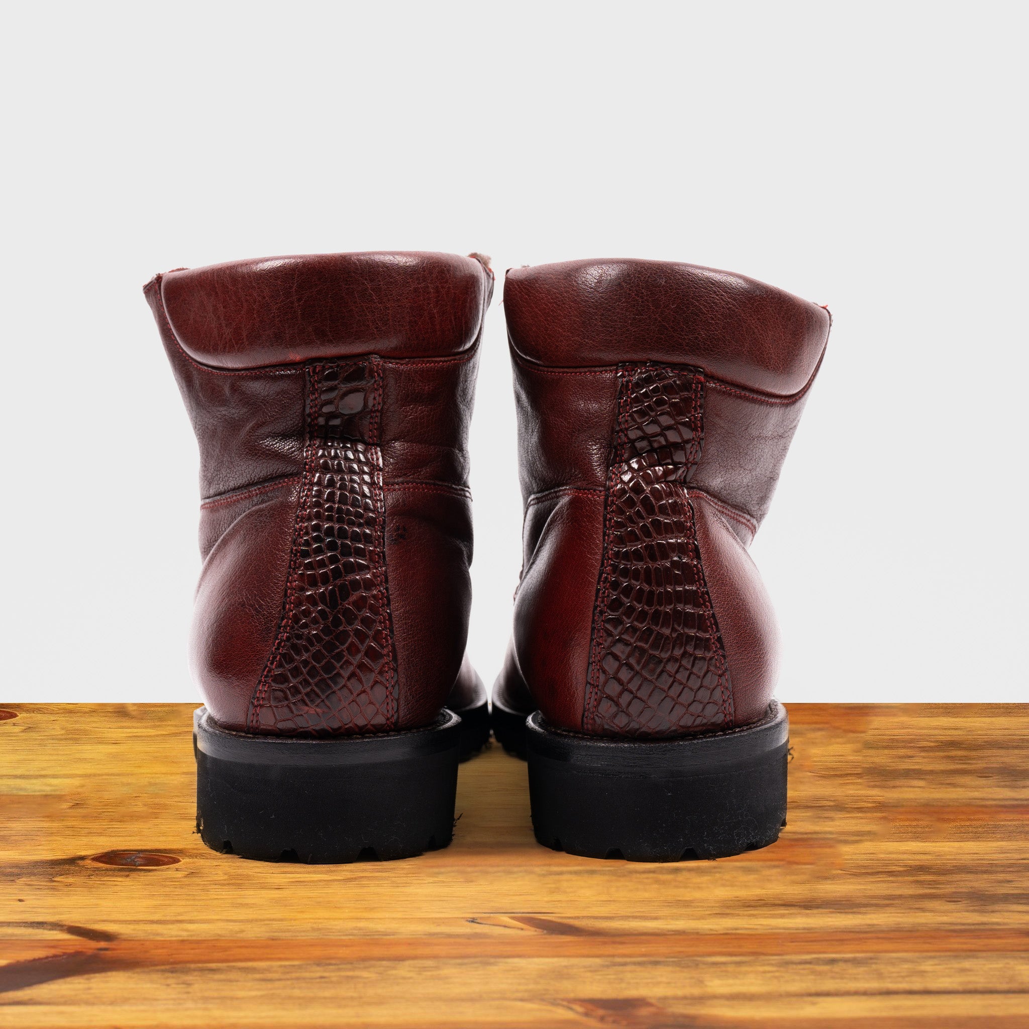 Back view of Cherry leather boots on a wooden surface