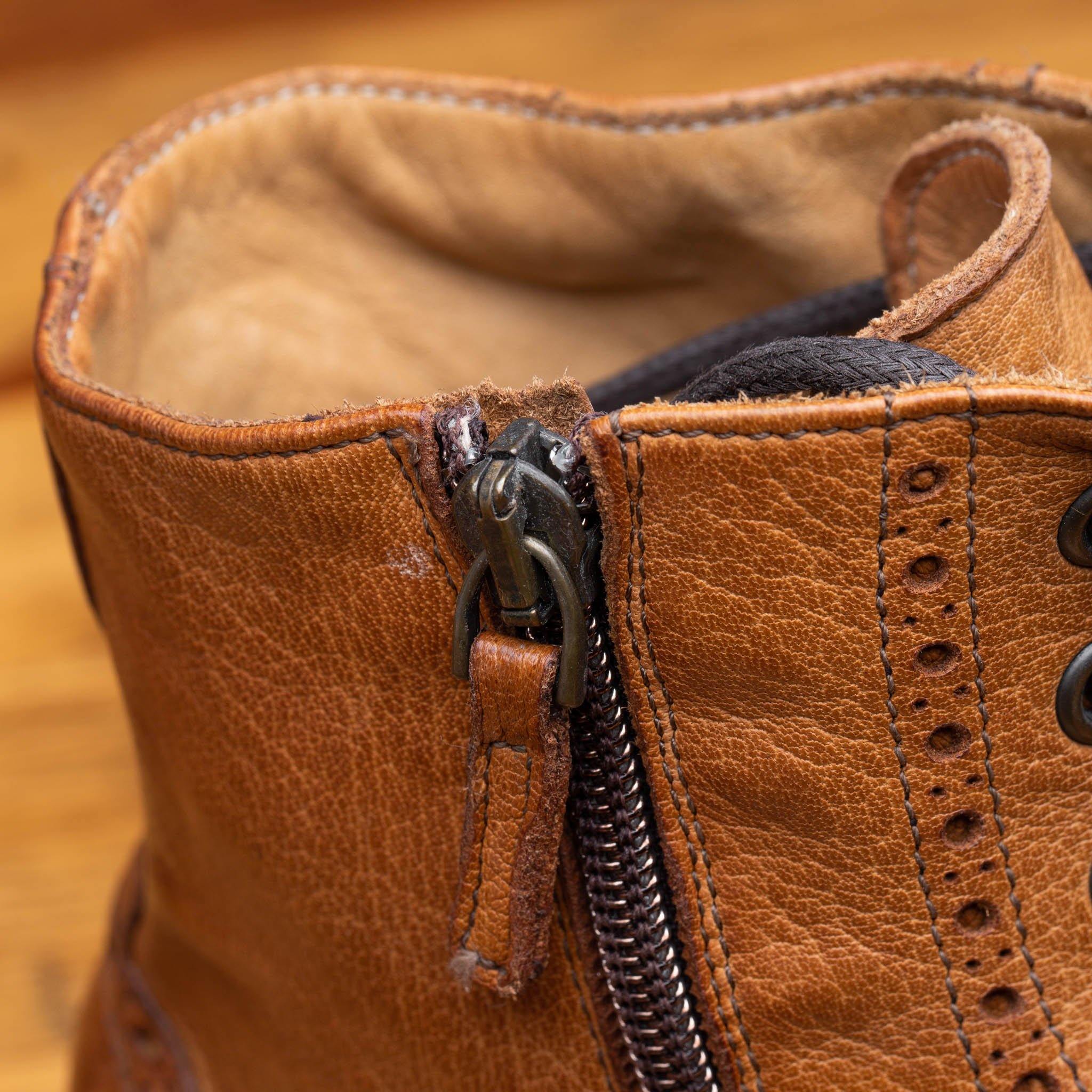 Brick leather boots Zip closure on a wooden surface