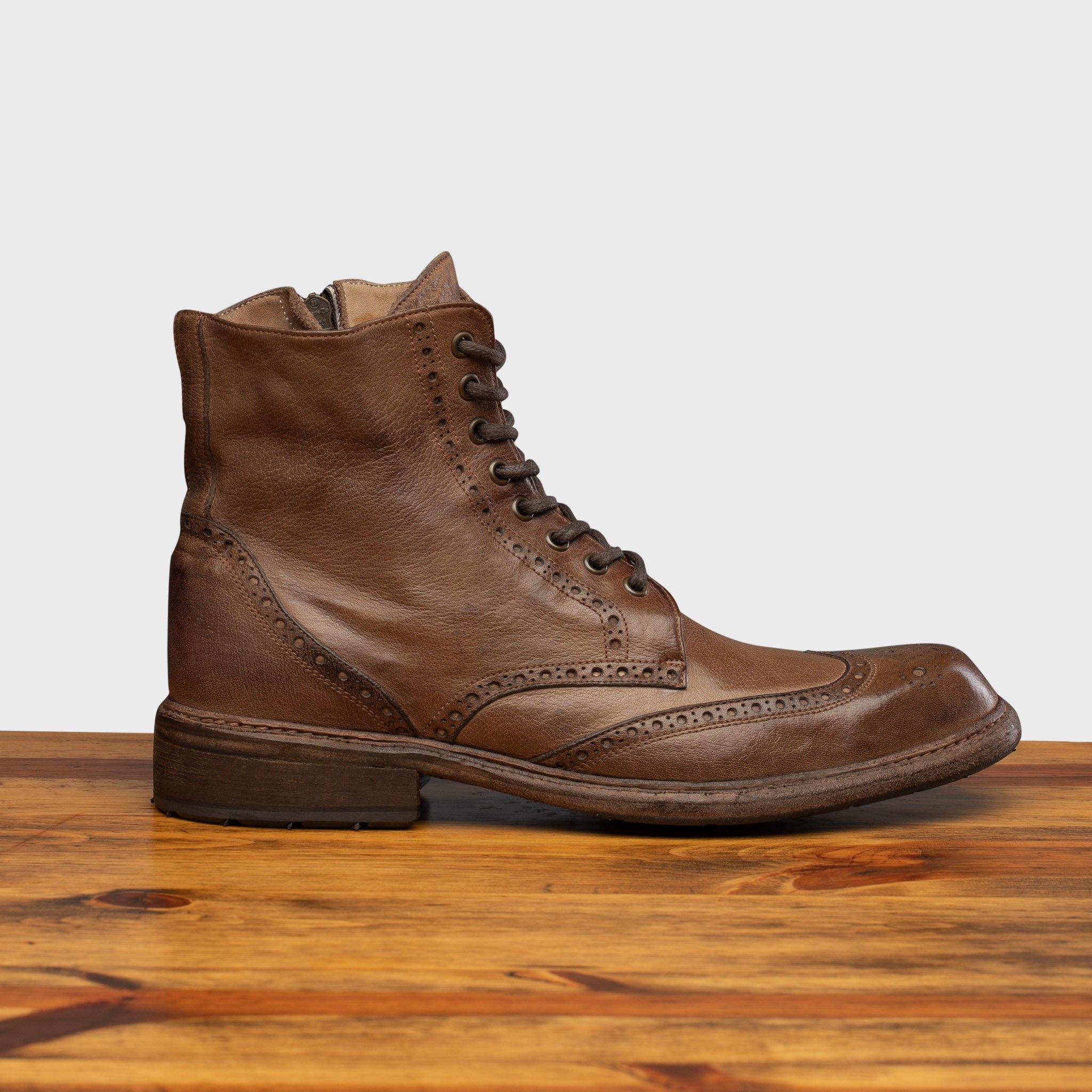 Moor leather boots on a wooden surface with a light gray background