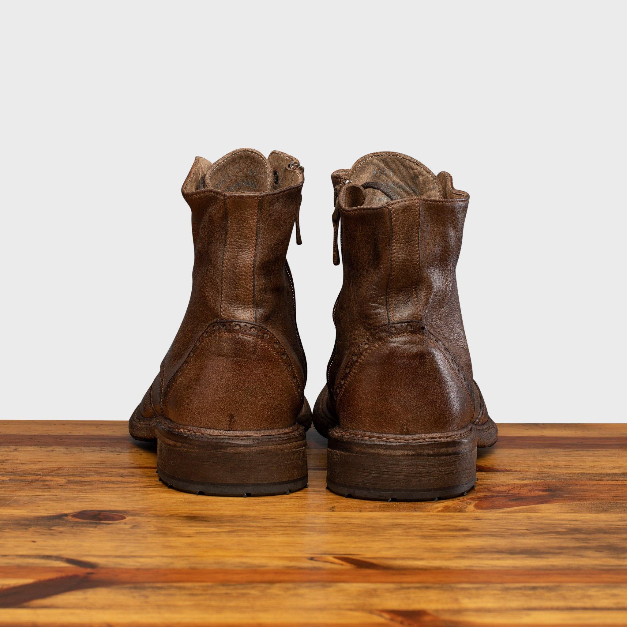 Pair of Moor leather boots on a wooden surface with a light gray background