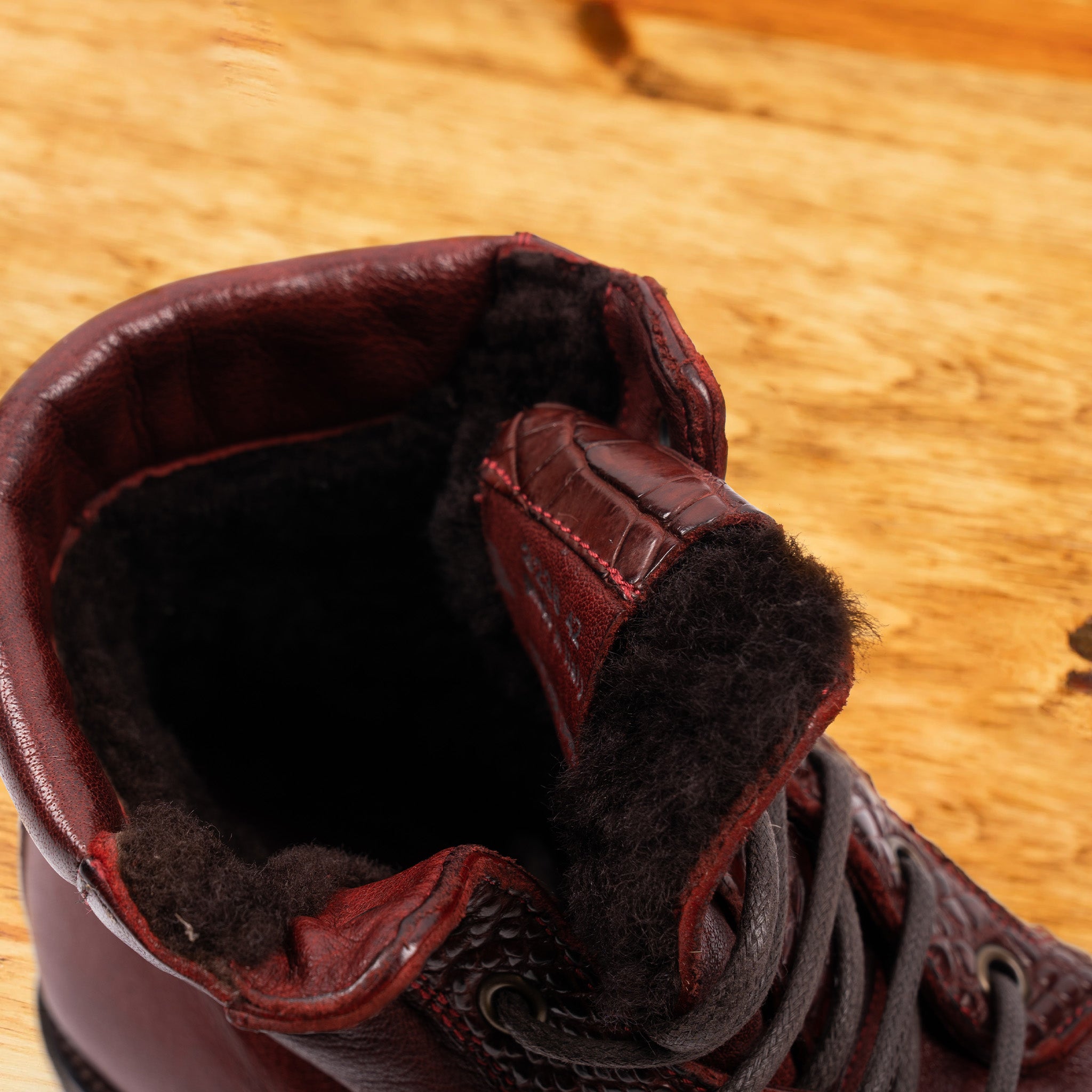 Close view of Cherry leather boots on a wooden surface