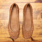 Pair of Brick woven flat shoe on a wooden surface