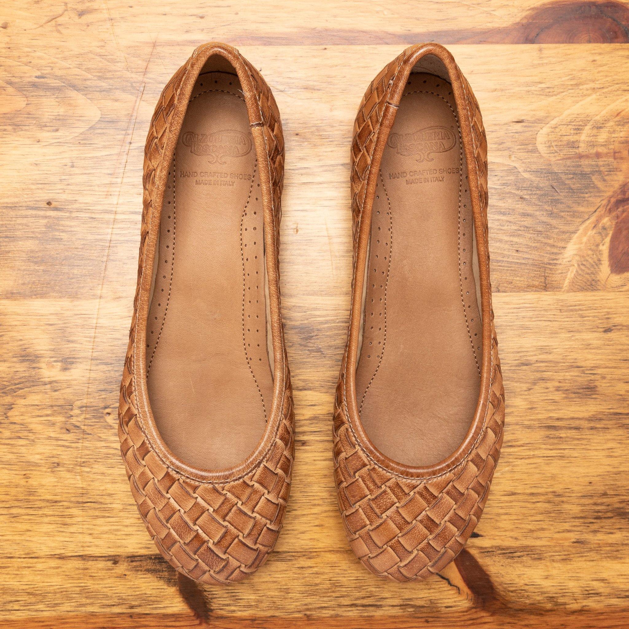 Pair of Brick woven flat shoe on a wooden surface