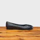 Navy Blue woven flat shoe on a wooden surface with a light gray background