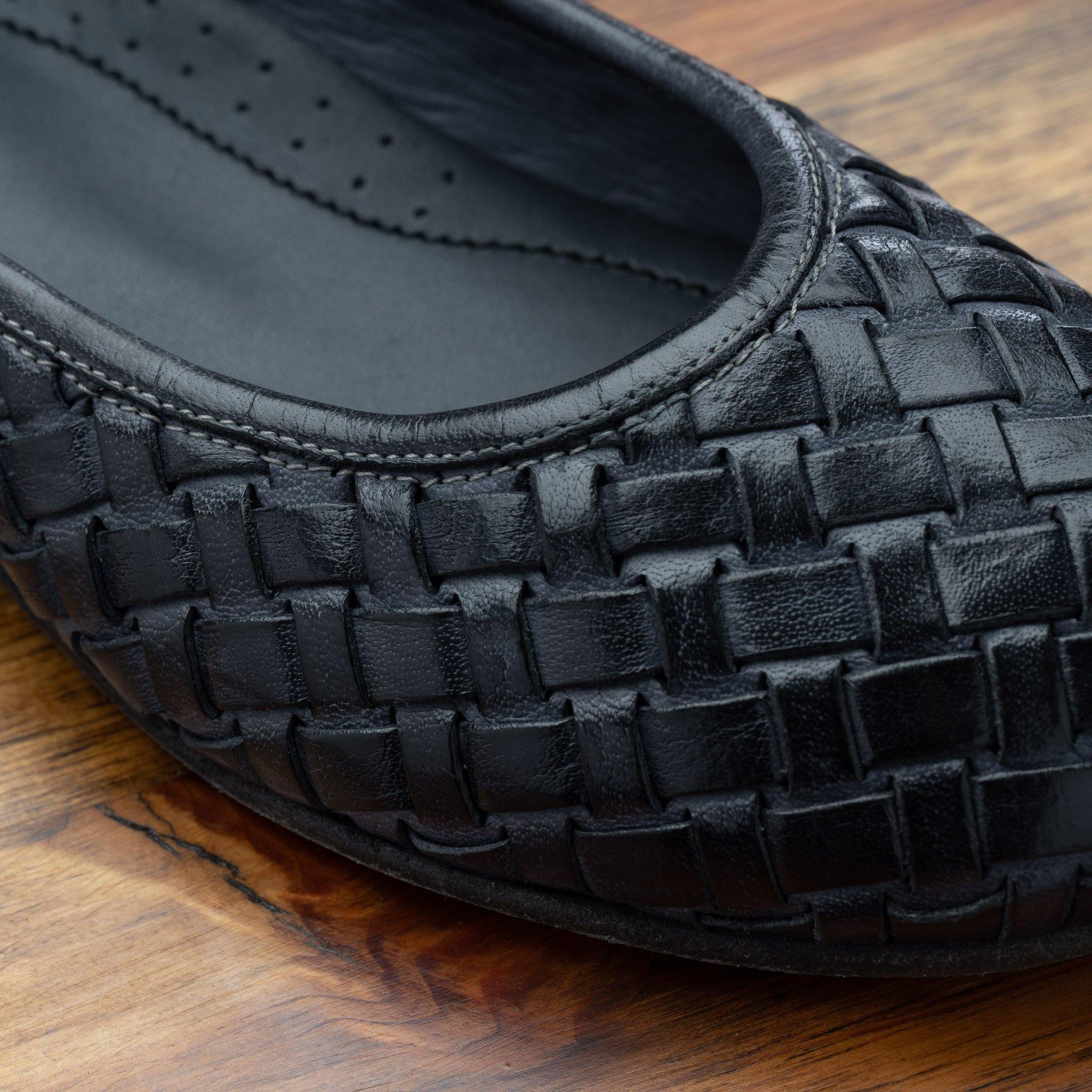 Close view of Navy Blue woven flat shoe on a wooden surface