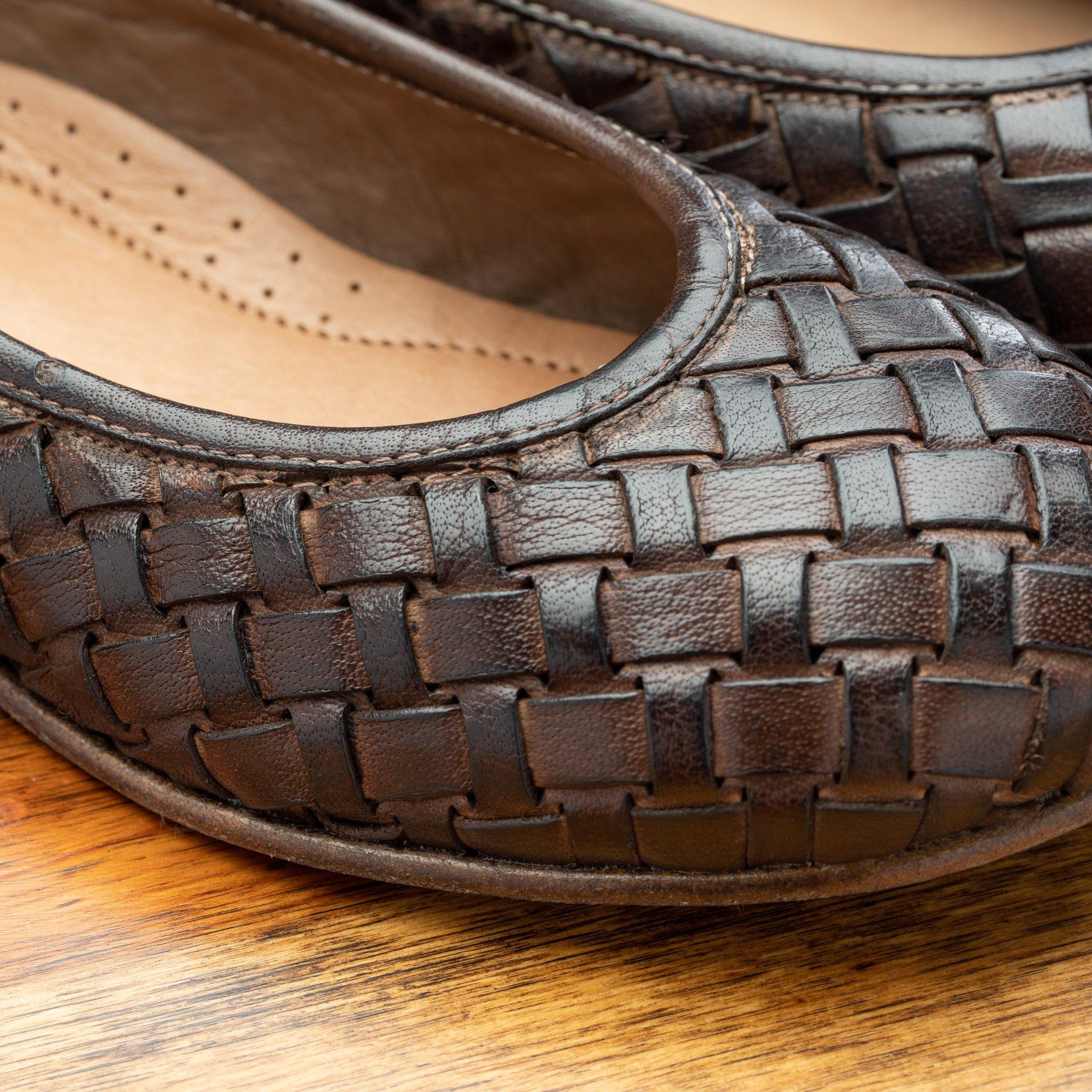 Close view of Tobacco woven flat shoe on a wooden surface