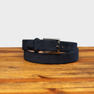Blue belt with a silver buckle on a wooden surface