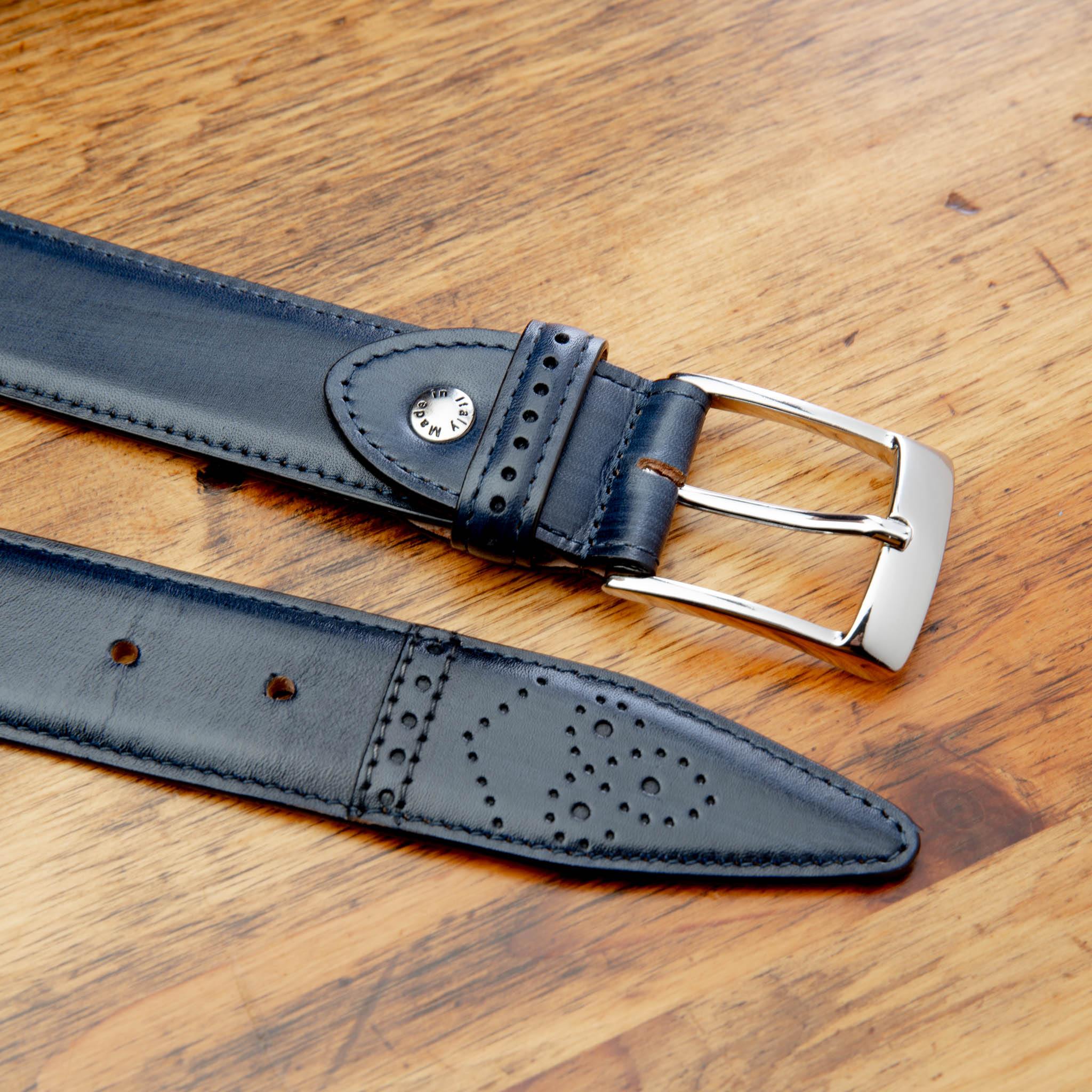 Blue leather belt with silver buckle on a wooden surface