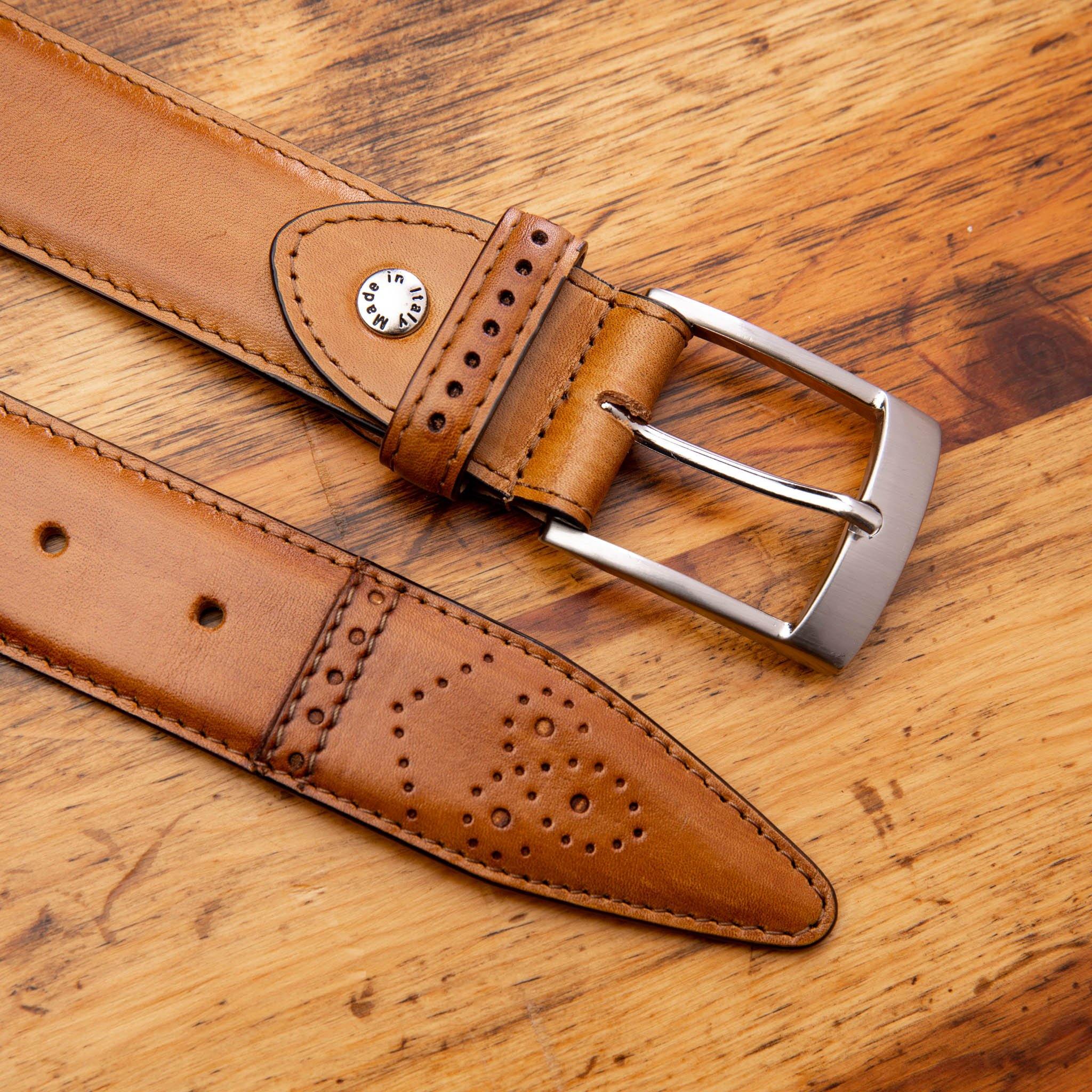 Chestnut leather belt with silver buckle on a wooden surface