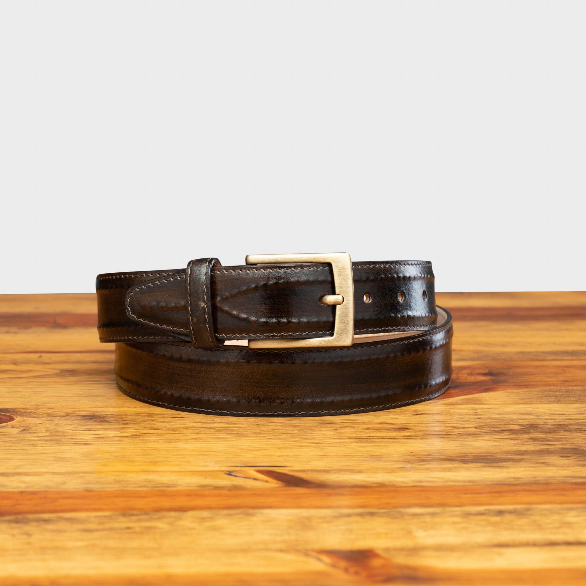 Dark Brown leather belt with a silver buckle on a wooden surface