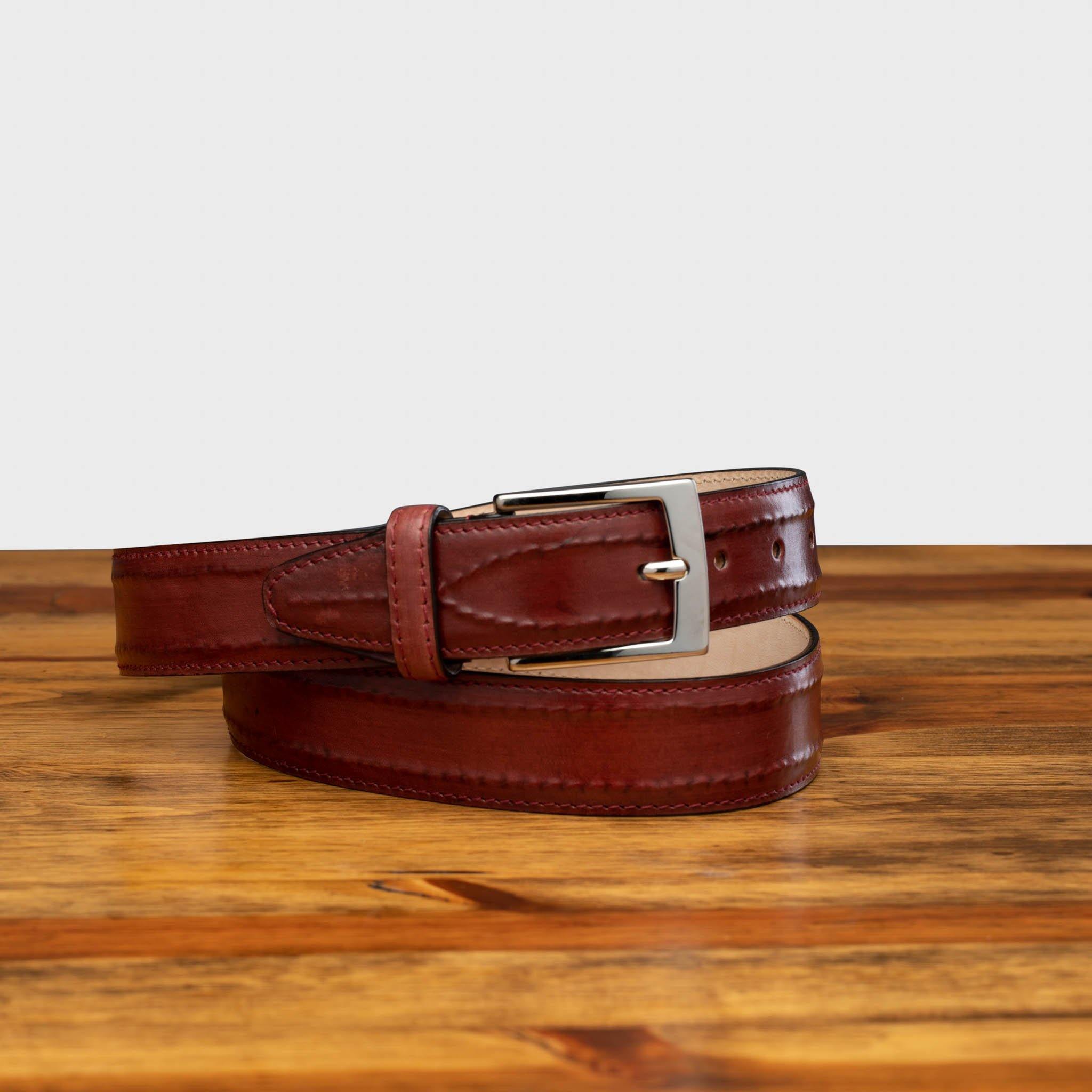 Porpora leather belt with a silver buckle on a wooden surface