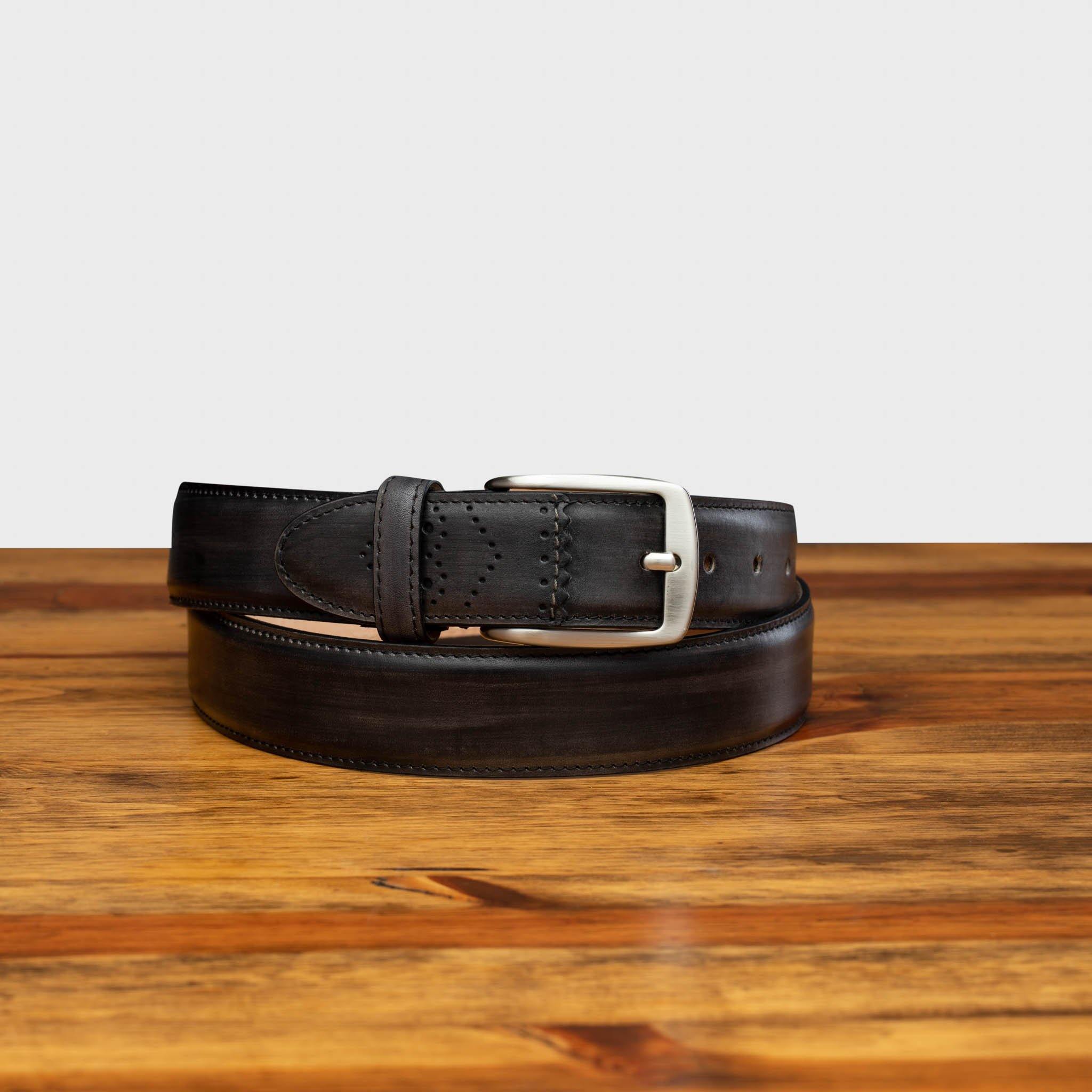 Graphite leather belt with a silver buckle on a wooden surface