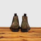 Back view of Camouflage-patterned boot on a wooden surface with a light gray background