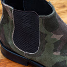 Close view of Camouflage-patterned boot on a wooden surface