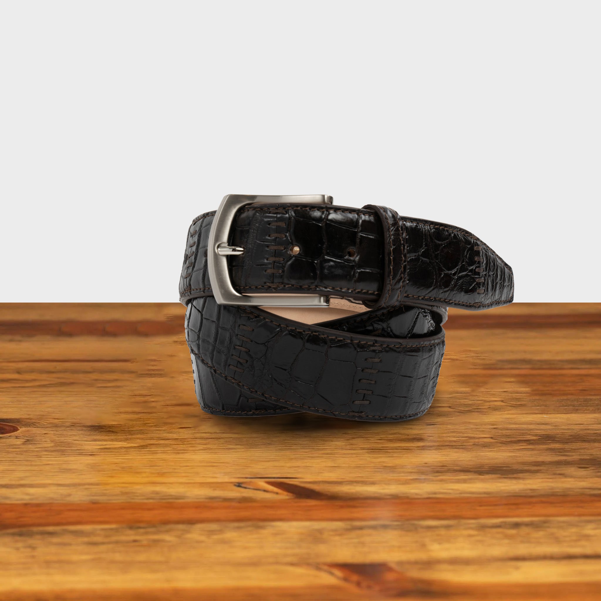 Dark Brown textured belt with a silver buckle on a wooden surface