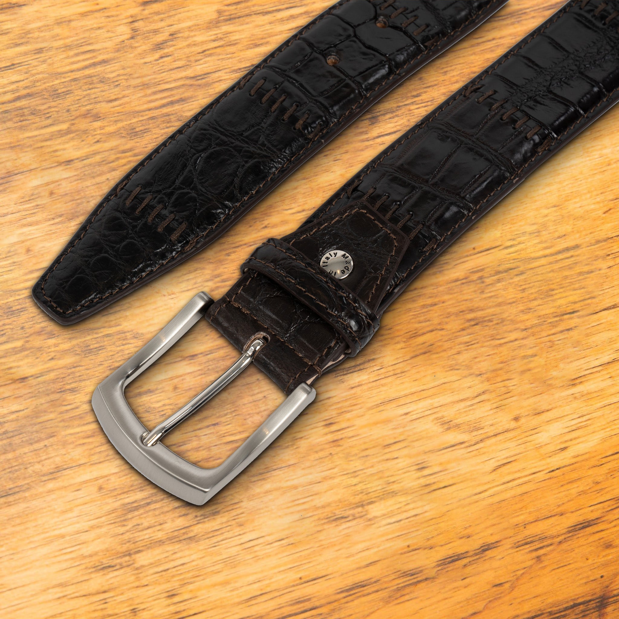 Dark Brown textured belt with a silver buckle on a wooden surface