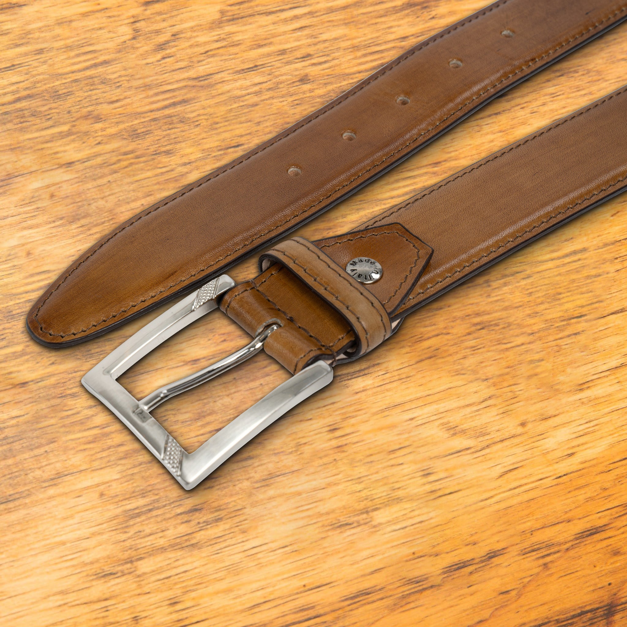 Dark Caramel leather belt with a black buckle on a wooden surface