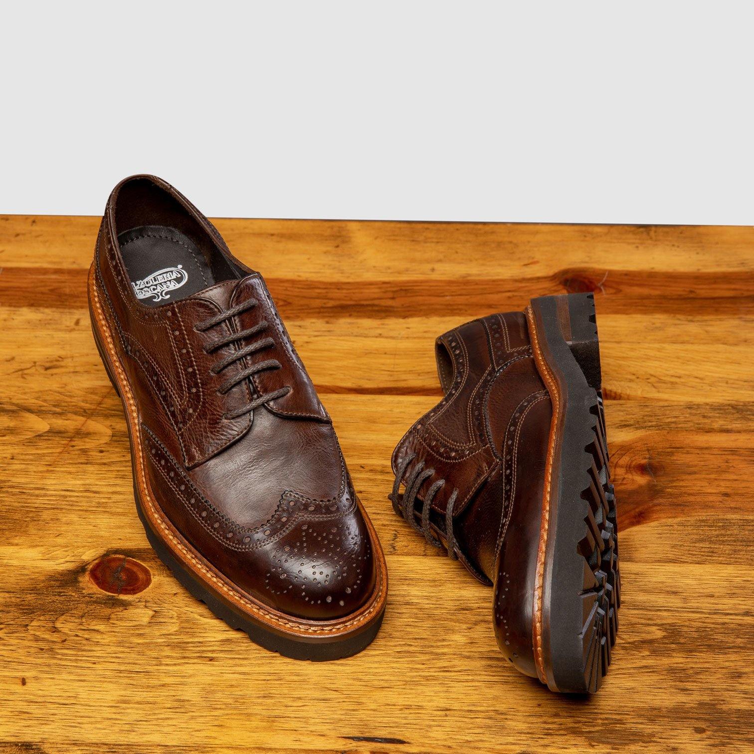 Pair of Brown leather shoes on a wooden surface