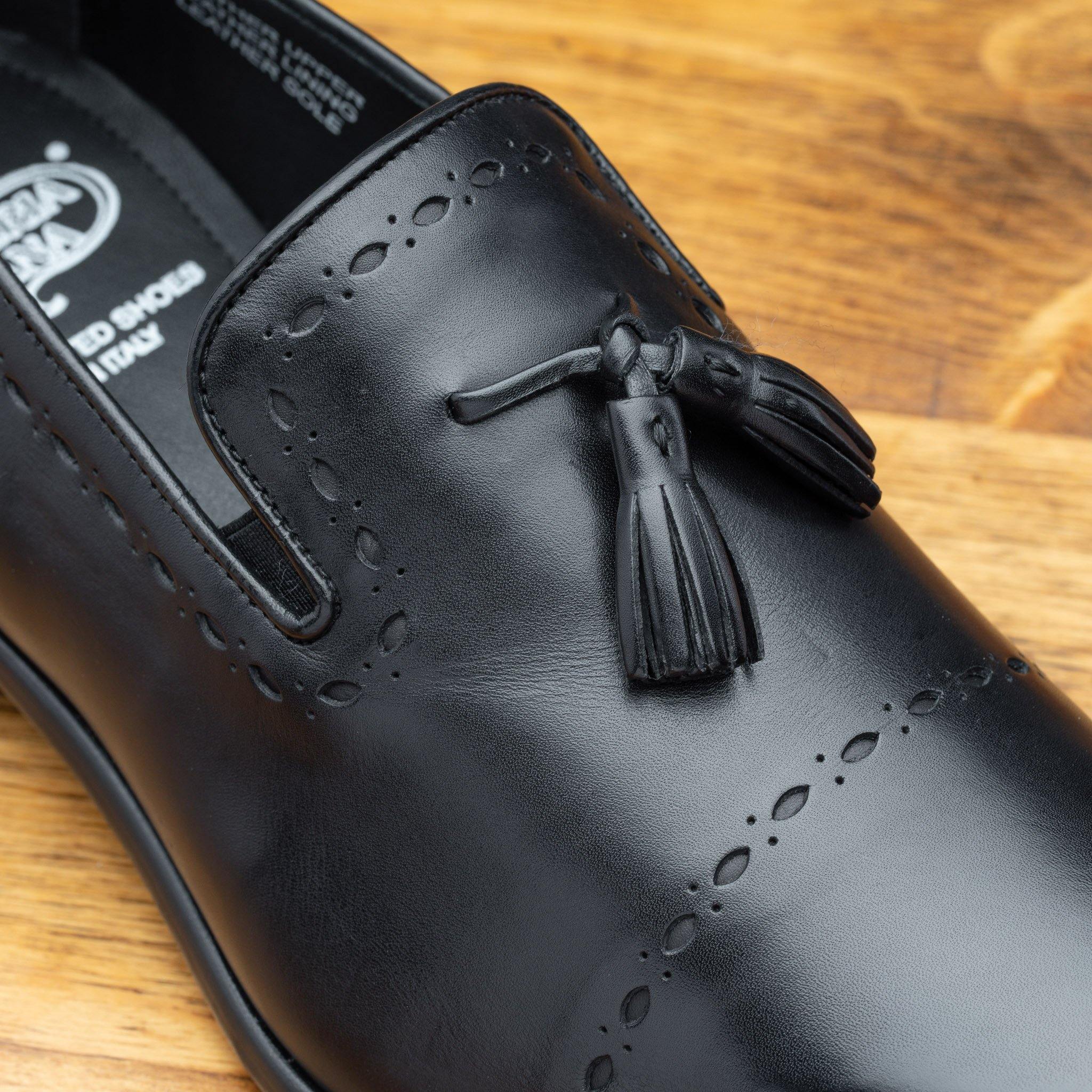 black leather loafer shoe on a wooden surface