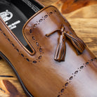 Chestnut leather loafer shoe on a wooden surface