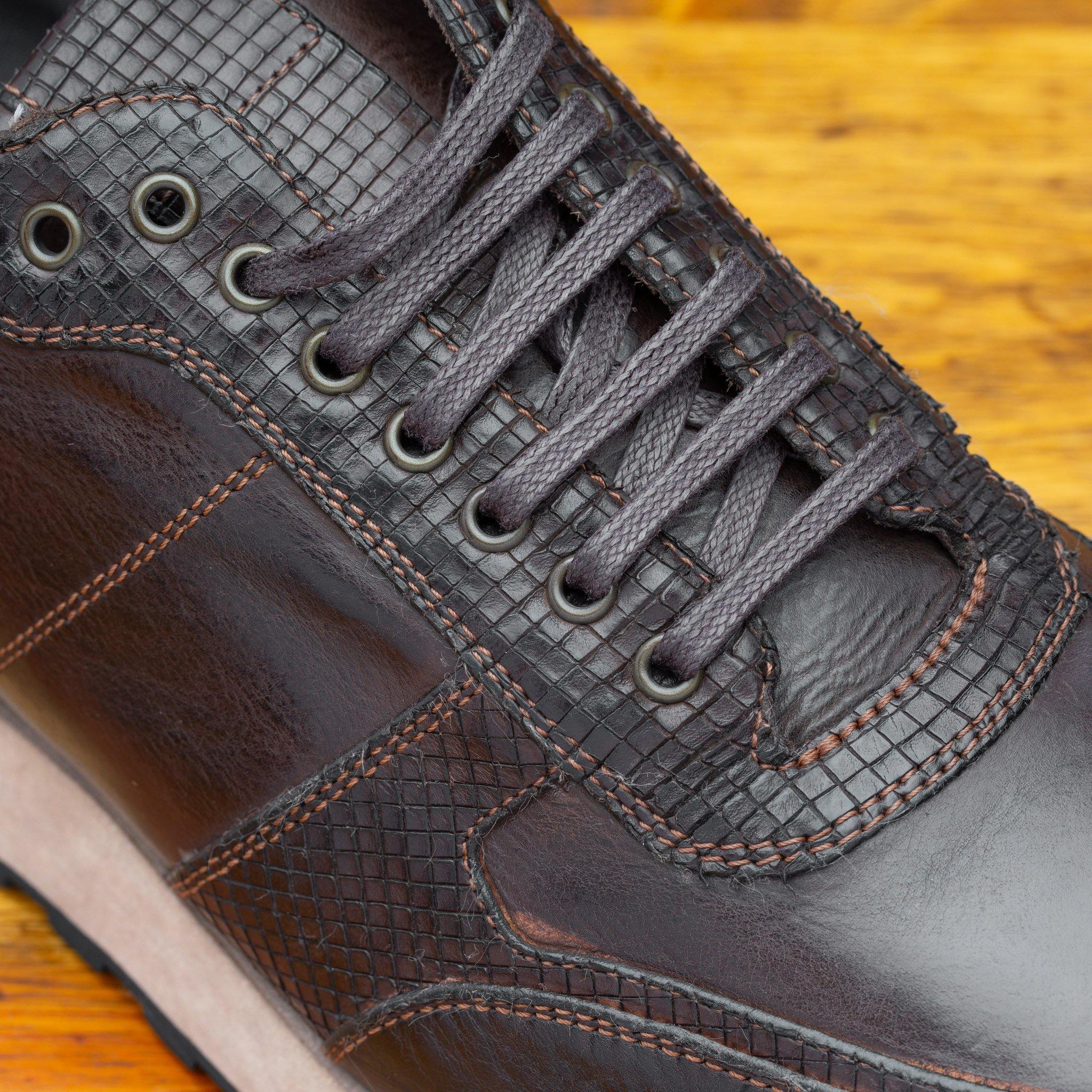 Close-up of Brown leather sneaker on a wooden surface