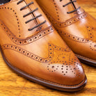 Close View of Brown leather dress shoe on a wooden surface