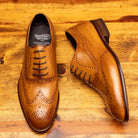 Pair of Brown leather dress shoe on a wooden surface