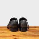 Back View of Gray leather dress shoe on a wooden surface with a light gray background