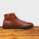 Brown leather high-top sneaker with a zipper on a wooden surface