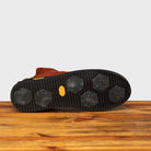 Outsole of Brown leather high-top sneaker with a zipper on a wooden surface