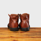 Back side of Brown leather high-top sneaker with a zipper on a wooden surface