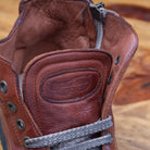 Close view of Brown leather high-top sneaker with a zipper on a wooden surface