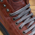 Close view Brown leather high-top sneaker with a zipper on a wooden surface