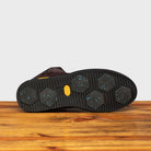 Outsole of Dark Brown leather high-top sneaker with a zipper on a wooden surface
