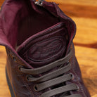 Close view of Dark Brown leather high-top sneaker with a zipper on a wooden surface