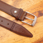 Dark Caramel leather belt with silver buckle on a wooden surface