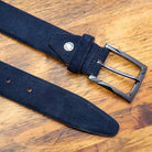 Blue belt with a silver buckle on a wooden surface
