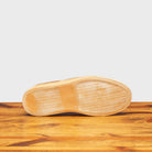 Outsole of woven brown slip-on shoes on a wooden surface