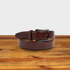 Porpora leather belt with a black buckle on a wooden surface