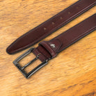 Porpora leather belt with a black buckle on a wooden surface