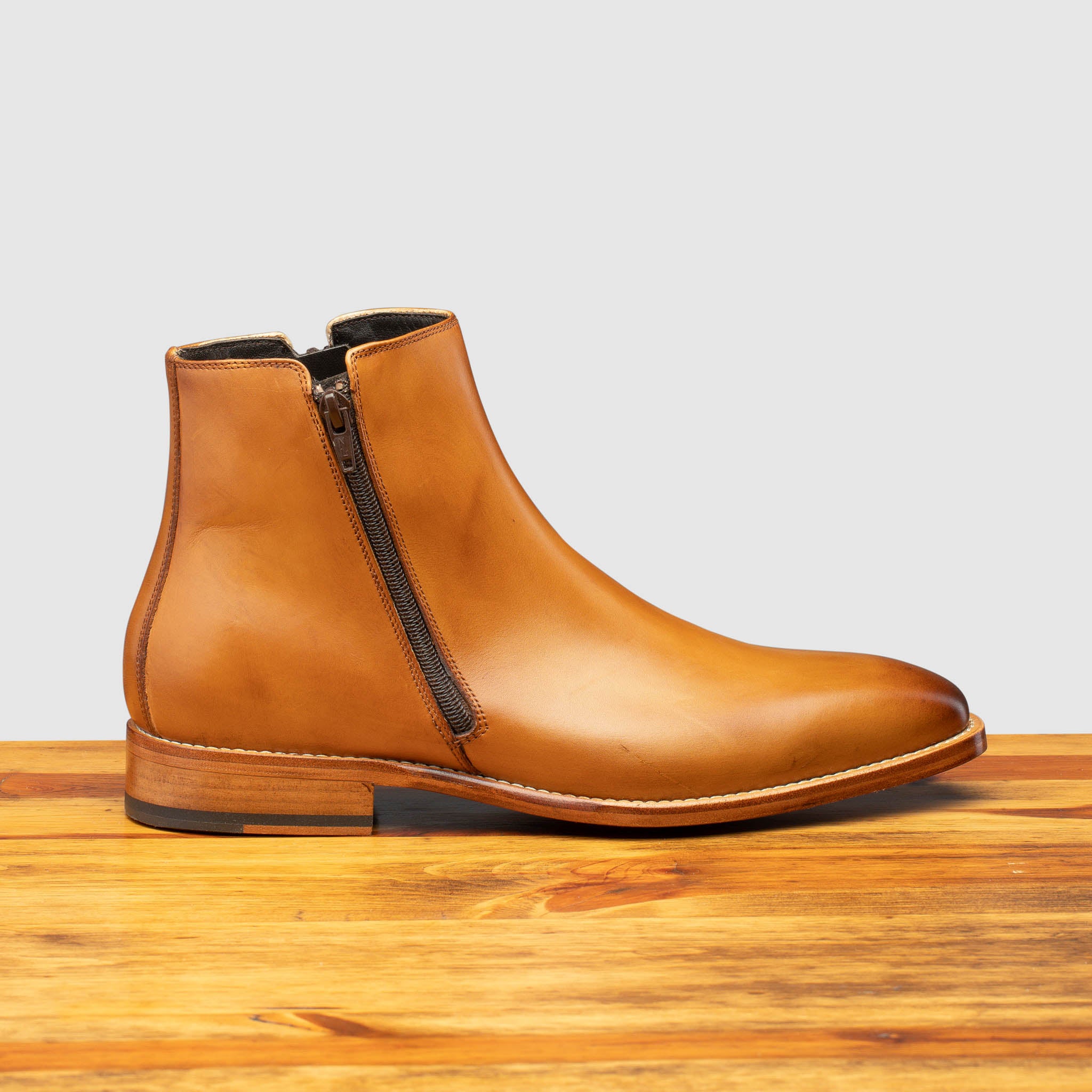 Chester leather ankle boot with zipper on a wooden surface