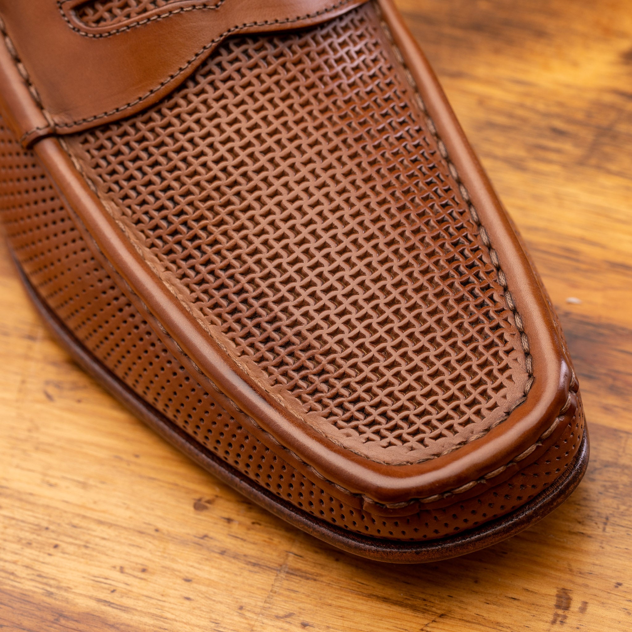 Brown leather loafer on a wooden surface