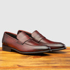 A Pair of Porpora leather loafer on a wooden surface with a light gray background