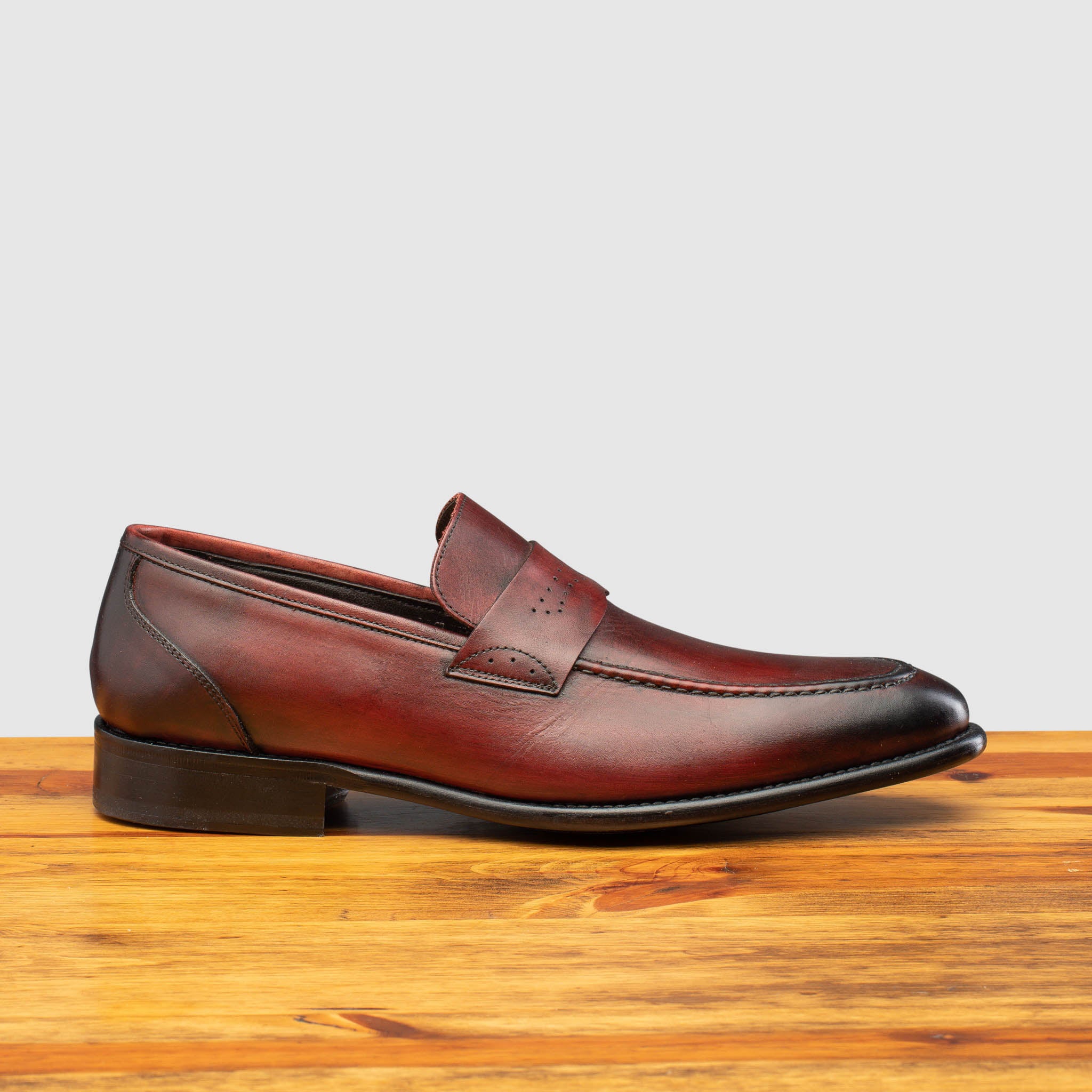 Porpora leather loafer on a wooden surface with a light gray background